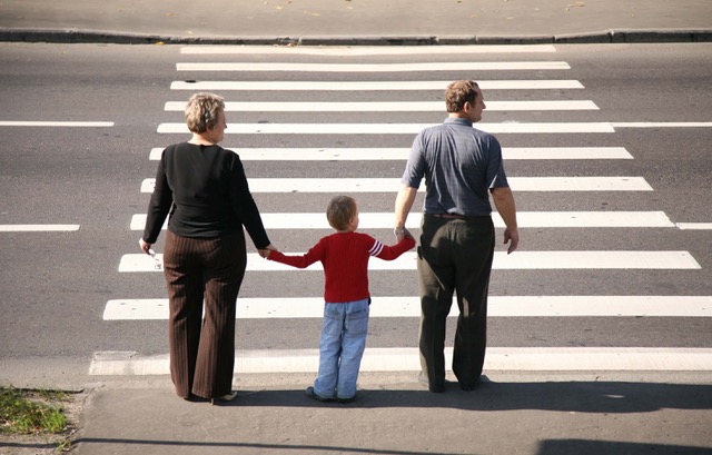 Pedestrians look before crossing the street to avoid a pedestrian accident.